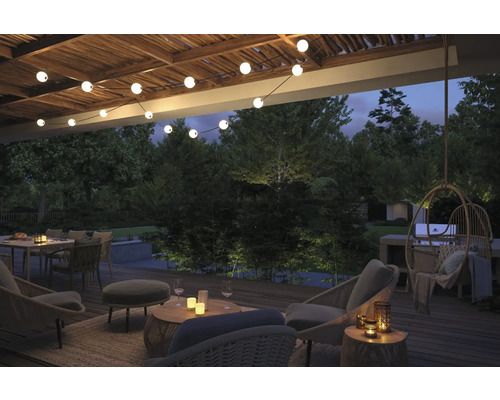 Terrasse d'ambiance avec mobilier de jardin, guirlande lumineuse et éclairage extérieur