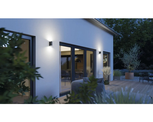 Aussenansicht eines Hauses mit Garten und beleuchteten Wandleuchten