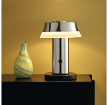 Dekorative Tischleuchte aus Metall neben einer Vase auf einem Tisch