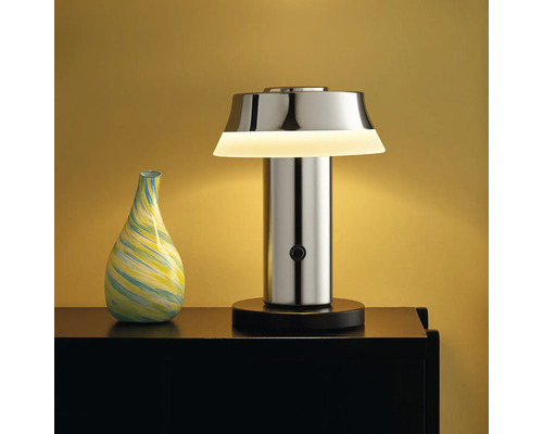 Dekorative Tischleuchte aus Metall neben einer Vase auf einem Tisch