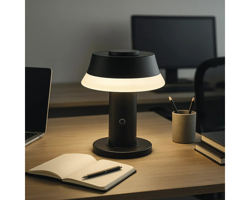 Schreibtisch mit beleuchteter Tischleuchte, Laptop und Notizbuch