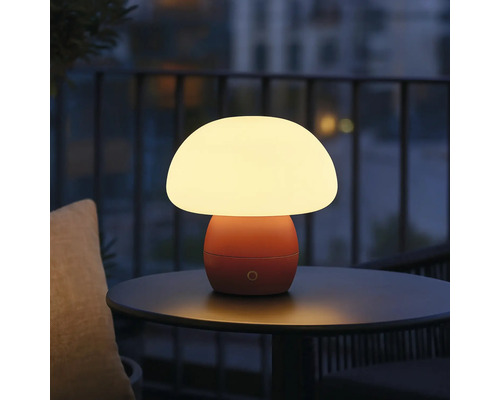 Pilzförmige Tischleuchte auf einem Tisch im Freien.