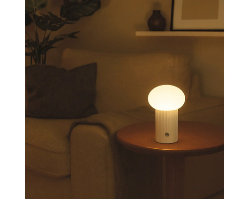 Tischleuchte auf einem Beistelltisch neben einem Sessel