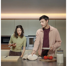 Paar bereitet Speisen in einer modernen Küche zu.