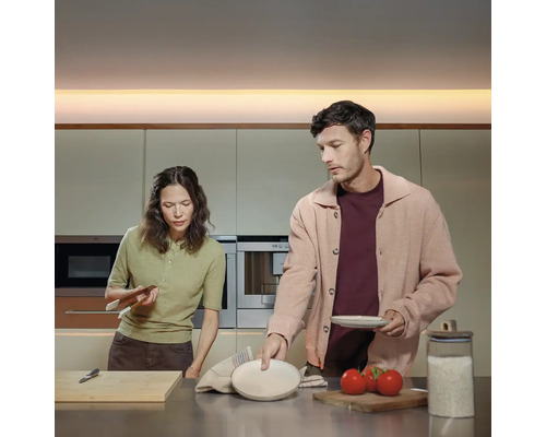 Ein Paar bereitet Essen in einer modernen Küche zu.