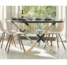 Table à manger avec quatre chaises, vaisselle et boissons dans une pièce lumineuse.