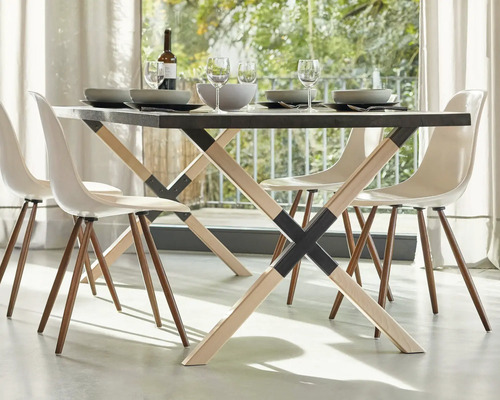 Table à manger avec quatre chaises, vaisselle et boissons dans une pièce lumineuse.