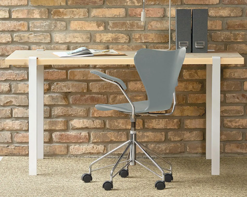 Bureau avec chaise de bureau devant un mur de briques