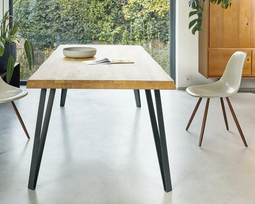 Table de salle à manger en bois avec pieds en métal et chaises dans une pièce lumineuse