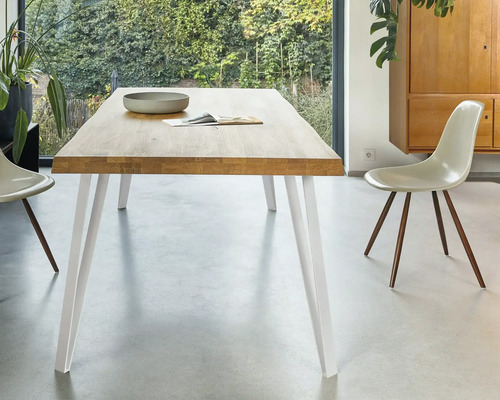 Esstisch mit Platte aus Holz und weißen Beinen im Esszimmer.