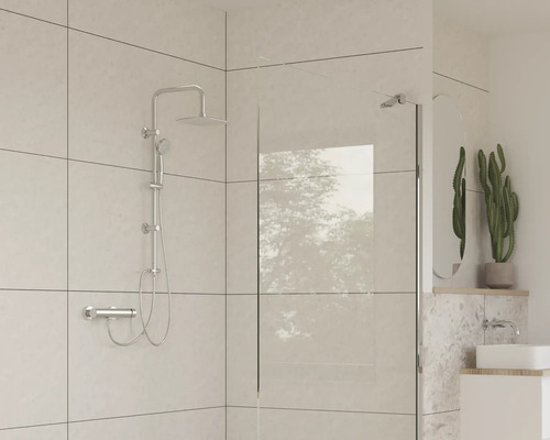 Badezimmer mit Duscharmatur, Duschwand und Waschbecken