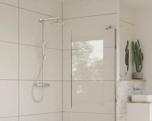 Salle de bain avec robinetterie de douche et paroi de douche en verre