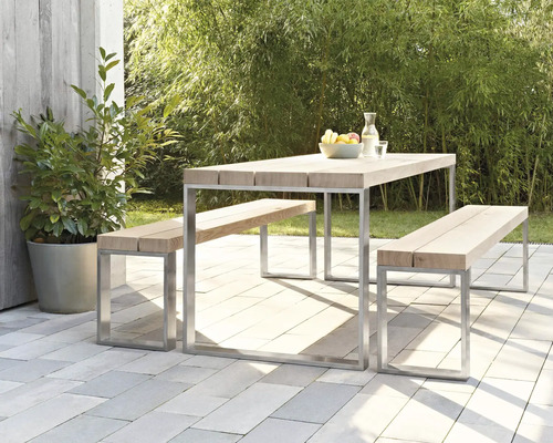Scène de jardin avec table en bois et bancs sur une terrasse carrelée
