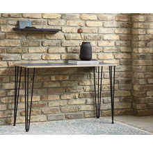 Table avec pieds en épingle à cheveux devant un mur de briques