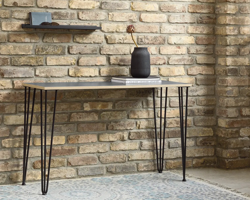 Table avec pieds en épingle à cheveux devant un mur de briques