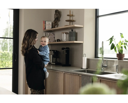 Cuisine claire avec étagères, évier, robinet et mère avec enfant