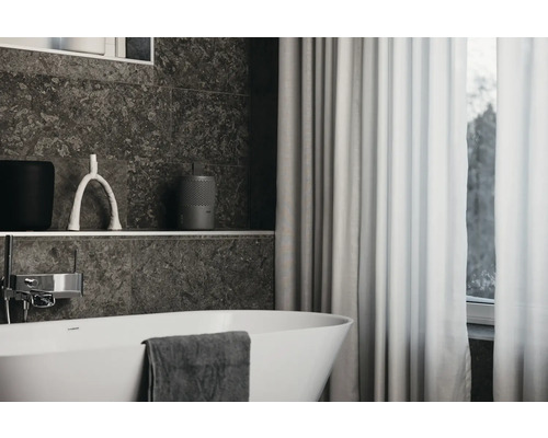 Salle de bain avec baignoire, rideau et étagère avec décorations