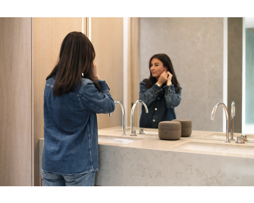 Modernes Badezimmer mit Doppelwaschbecken, Armaturen, Spiegel und tragbarem Lautsprecher