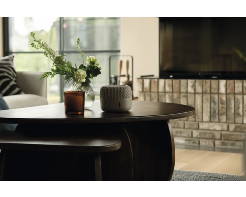 Szene mit einem Luftentfeuchter auf einem Tisch neben einer Vase und einer Kerze in einem Wohnzimmer.