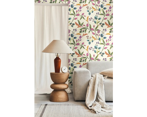 Einrichtungsidee mit einer Wandtapete mit Blumenmuster, einem Holztisch, einer Lampe und einem hellen Sofa