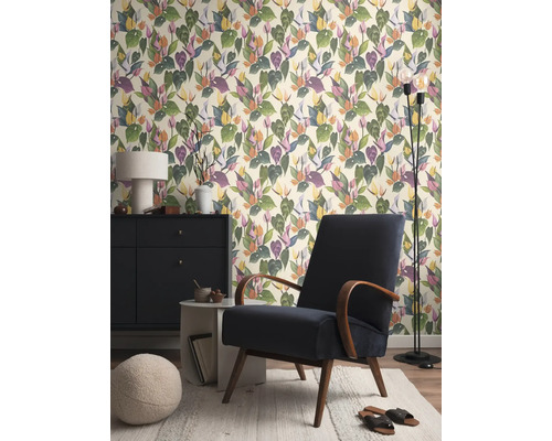 Wohnzimmer mit gemusterter Tapete, Sessel, Stehlampe und Kommode