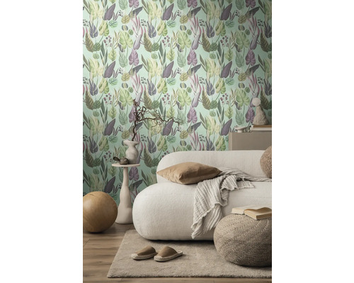 Wohnzimmer mit einer Wand mit botanischer Mustertapete, Sofa und Teppich