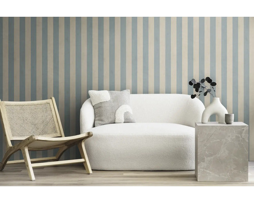 Wohnzimmer-Szene mit Sessel, Sofa und Beistelltisch vor einer gestreiften Wand