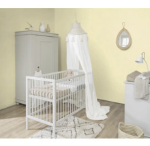 Helles Kinderzimmer mit Gitterbett, Baldachin, Wickelkommode, Kleiderschrank und Dekoration