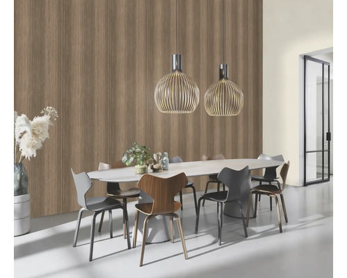 Salle à manger avec table à manger, chaises et suspensions devant un mur avec papier peint imitation bois