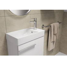 Lavabo avec robinet, serviette et porte-serviettes dans une salle de bain