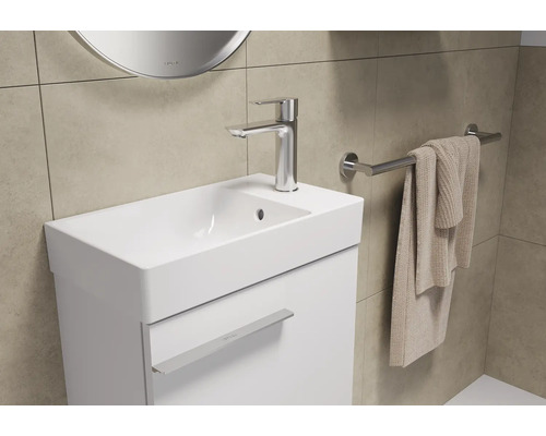 Lavabo avec robinet, serviette et porte-serviettes dans une salle de bain