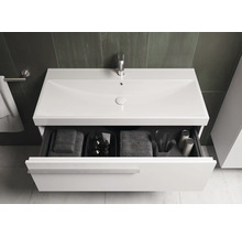 Meuble sous-lavabo avec tiroir ouvert, serviettes et accessoires de salle de bain