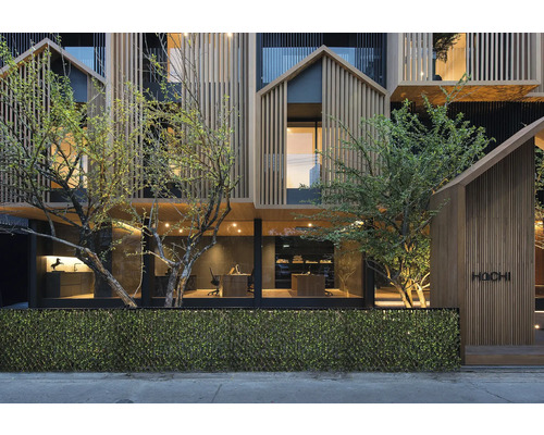 Façade d'un bâtiment moderne avec revêtement en bois et végétation