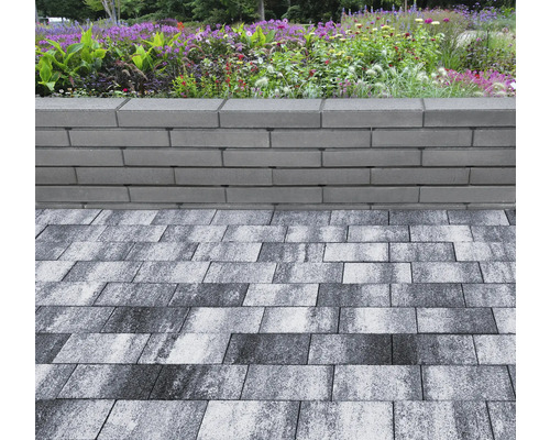 Graue Pflastersteine und Mauersteine im Garten.