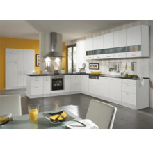 Cuisine claire avec armoires blanches, hotte en acier inoxydable et plans de travail foncés.