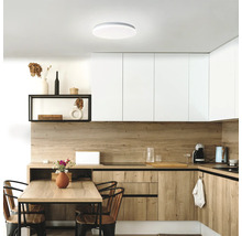 Cuisine lumineuse avec éléments en bois, table à manger et plafonnier