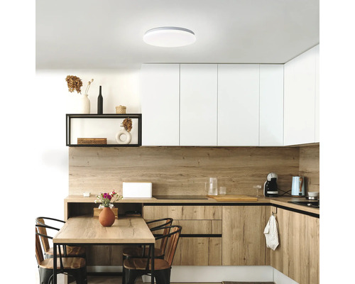 Cuisine lumineuse avec éléments en bois, table à manger et plafonnier