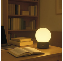 Dekorative Tischleuchte auf einem Schreibtisch mit Büchern und einem Laptop