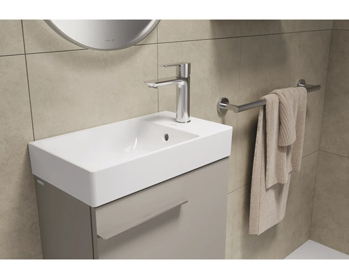 Meuble-lavabo avec armoire, robinet et porte-serviettes dans la salle de bains