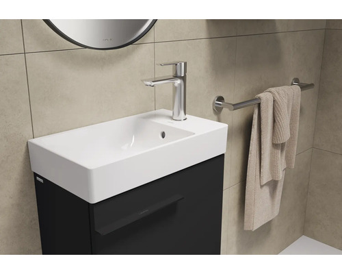 Lavabo avec robinet, serviette et porte-serviettes dans la salle de bain