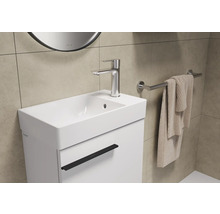 Lavabo avec robinet, serviette et porte-serviettes dans la salle de bain