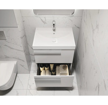 Meuble-lavabo de salle de bain avec tiroir ouvert, serviettes et produits de soin