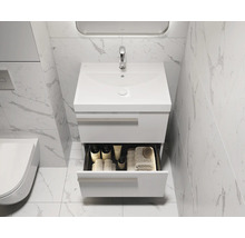 Salle de bains avec meuble sous-lavabo, tiroir ouvert et divers accessoires de salle de bains