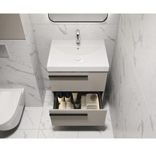 Meuble-lavabo de salle de bain avec tiroir ouvert, robinetterie et serviettes