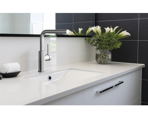 Waschtisch mit Armatur und weißen Lilien in Vase