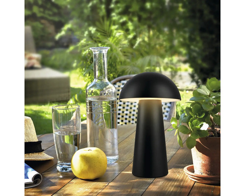 Tischleuchte im Pilzdesign auf einem Holztisch im Freien