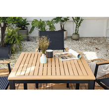 Table de jardin carrée avec décoration et chaises dans un espace extérieur.