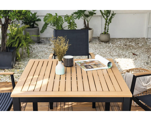 Table de jardin carrée avec décoration et chaises dans un espace extérieur.