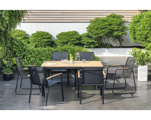 Scène de jardin avec table de jardin et chaises sur la terrasse, entourée de plantes