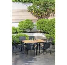 Scène de jardin avec une table à manger et des chaises entourées d'une végétation luxuriante